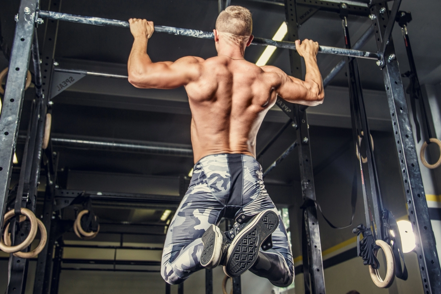 shirtless-man-pulling-up-horizontal-bar-gym.jpg